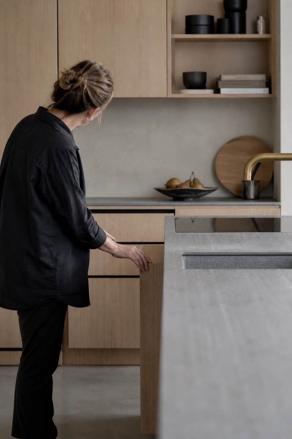 Een keukenspecialist controleert de laden van een hedendaagse keuken in licht hout